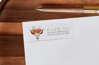 White stationery with a floral skull design on a wooden surface