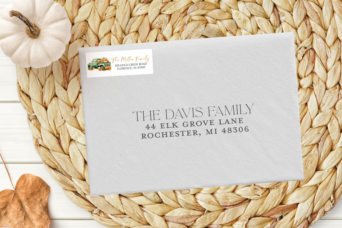 Envelope with address label on a woven mat with a pumpkin and leaf