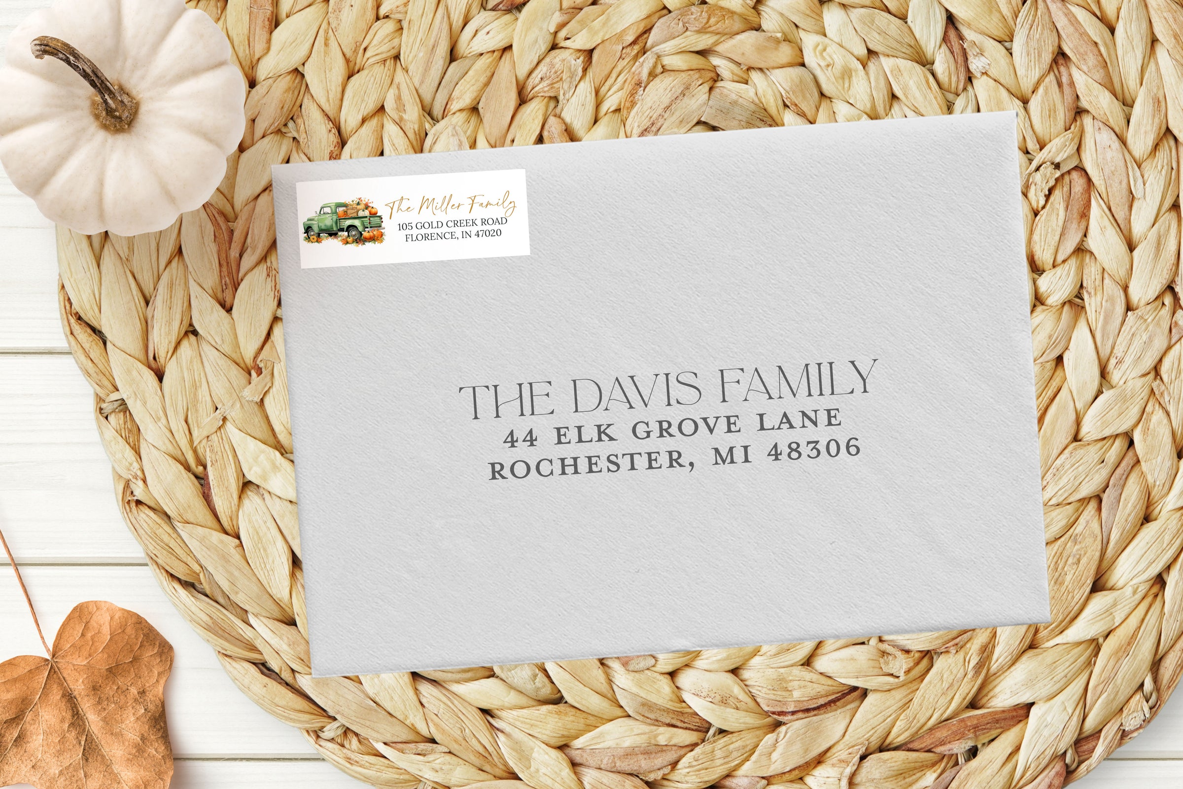 Envelope with address label on a woven mat with a pumpkin and leaf