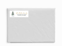 White envelope with a return address label featuring a tree design on a white background