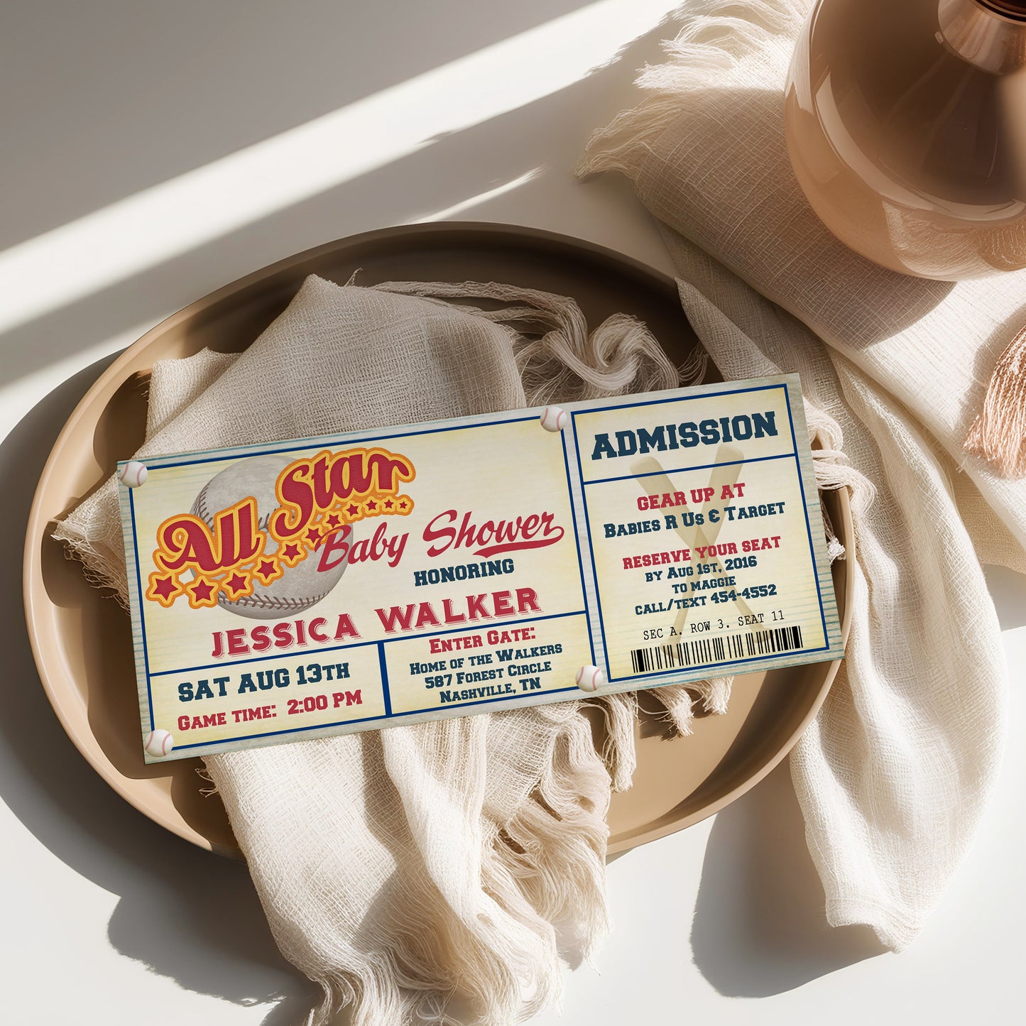 Invitation card for a baby shower on a textured surface with a lamp in the background