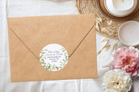 A kraft paper envelope with a round floral label featuring the text 'Mr. & Mrs.