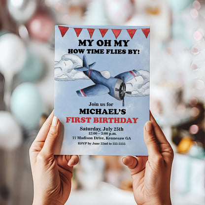 Birthday invitation card with airplane illustration held by hands against a blurred background