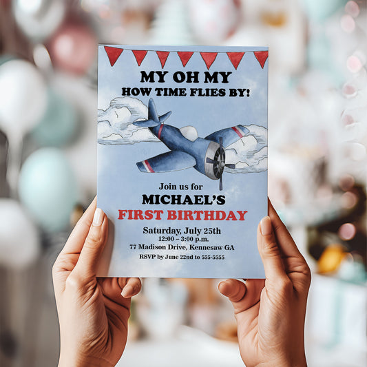 Birthday invitation card with airplane illustration held by hands against a blurred background
