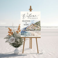 Wedding welcome sign with beach scene and floral arrangement on a white background