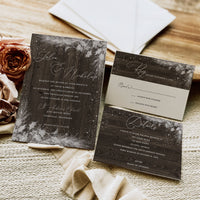 Wedding invitation set with floral design on a wooden surface
