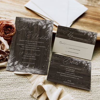 Wedding invitation set with floral design on a wooden surface